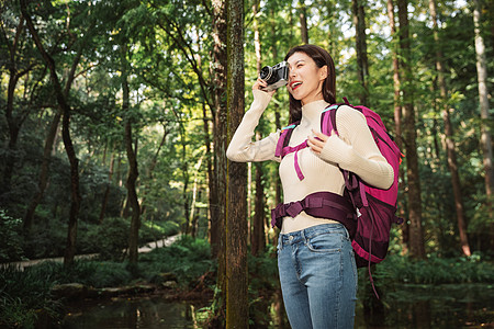 青年女性在森林里拍照图片