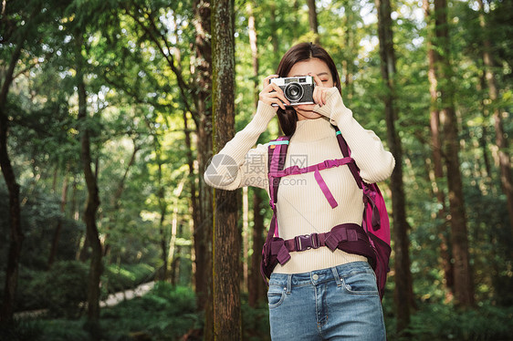 青年女性在森林里拍照图片