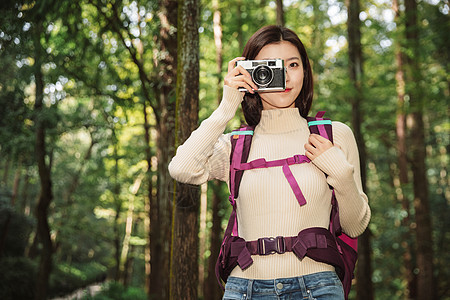 青年女性在森林里拍照图片