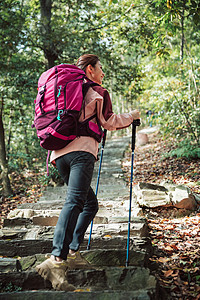 用登山杖爬山的女性形象背景图片