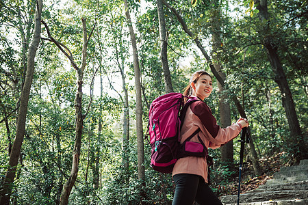 背包爬山用登山杖爬山的女性形象背景