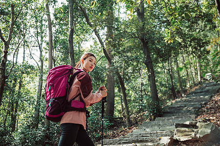 用登山杖爬山的女性形象背景图片