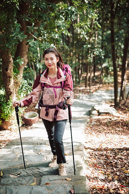 用登山杖爬山的女性形象图片