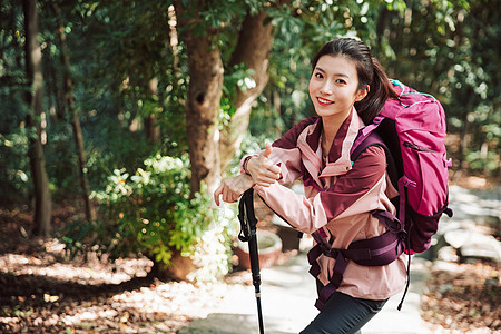 用登山杖爬山的女性形象图片