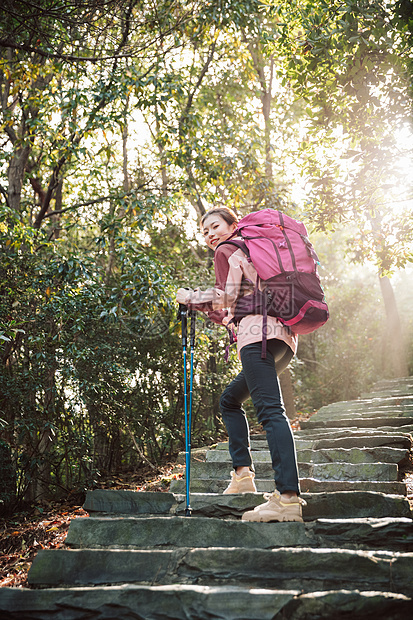 女生坐在山间小路上休息图片