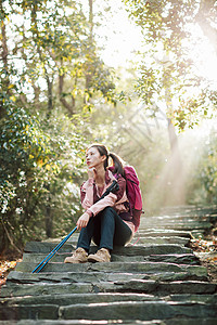 女生坐在山间小路上休息图片