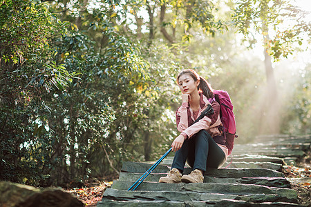 女生坐在山间小路上休息图片