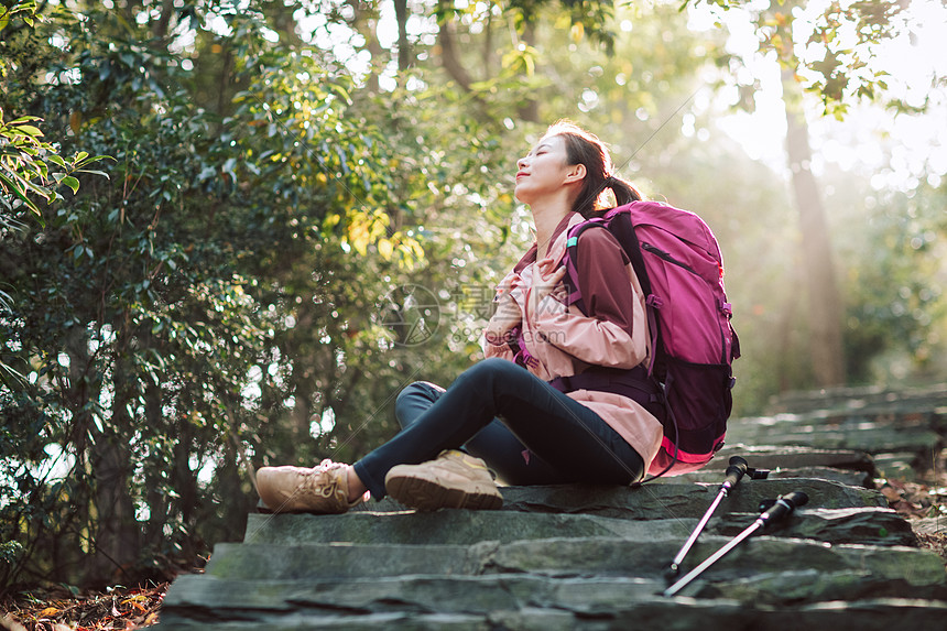 女生坐在山间小路上休息图片