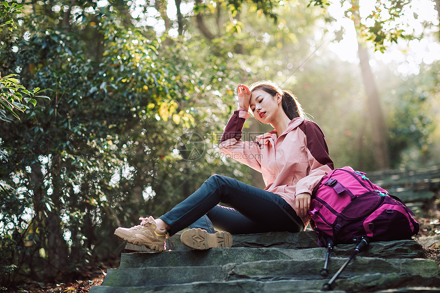 女生坐在山间小路上休息图片