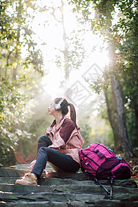 登山人物女生坐在山间小路上听音乐背景