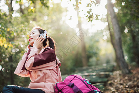 女生户外爬山女生坐在山间小路上听音乐背景