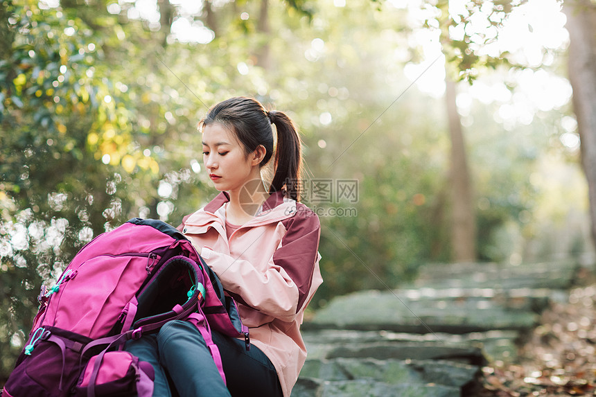 女生坐在山间小路上休息图片