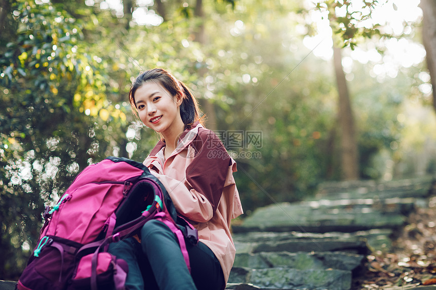 女生坐在山间小路上休息图片