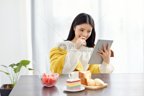 居家美女吃早点玩平板电脑图片