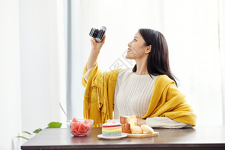 居家美女拿相机拍照图片