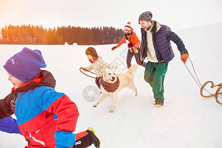 一家人和狗在雪地里奔跑图片