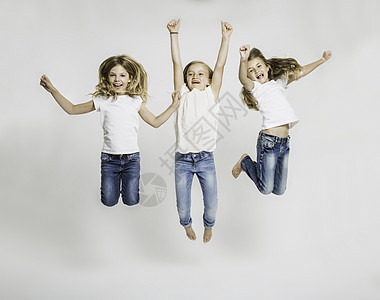 三个女孩在空中跳跃的摄影棚肖像背景图片