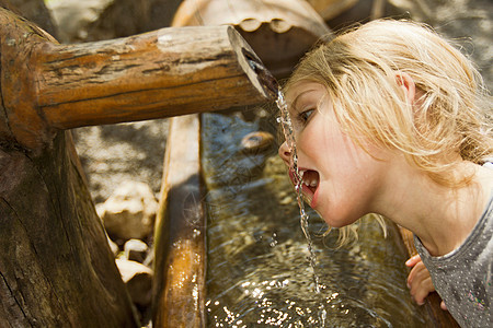 女孩从喷水口喝水图片