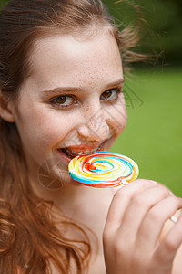 在公园吃棒棒糖的小女孩图片