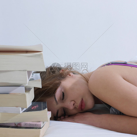 在书旁边睡着的年轻女人图片