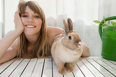 年轻的女人和一只宠物兔子图片