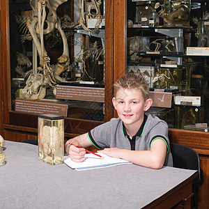 坐在博物馆桌子旁的男孩图片