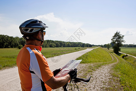 骑自行车的人在乡村道路上看地图图片