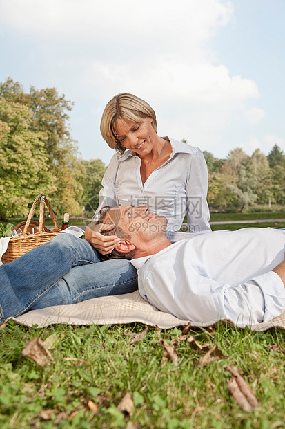 一对躺在野餐毯上的中年夫妇图片