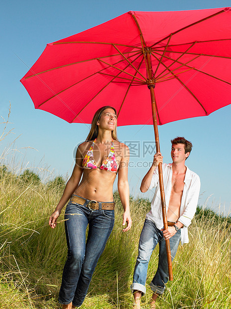 在田里带着遮阳伞的情侣图片
