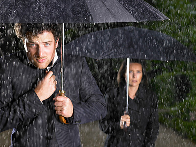 男人和女人拿着雨伞，下雨图片