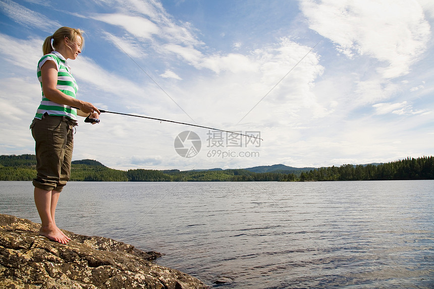 在湖中钓鱼的年轻女子图片