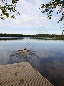 在平静的湖中游泳的人图片