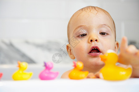 男孩在浴缸里玩塑料鸭子图片
