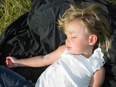 在阳光下睡在田里的女孩图片