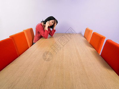 在会议桌旁沉思的女商人图片