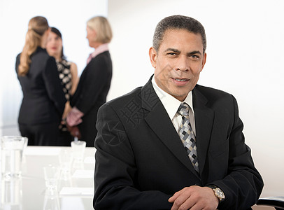 企业?坐在办公室里微笑的男子背景