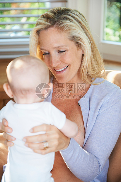 微笑的母亲抱着婴儿图片