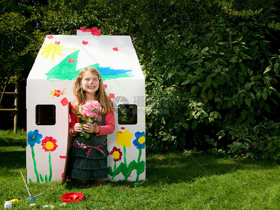一个女孩的纸房子在草地上图片