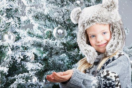 雪下的女孩，在圣诞树旁图片