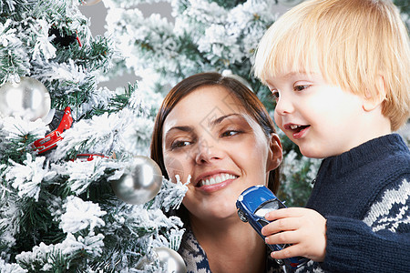 母亲和儿子装饰圣诞树高清图片