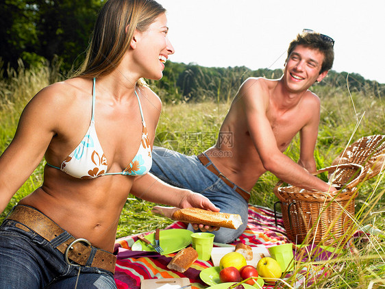 一对夫妇在田野里野餐图片