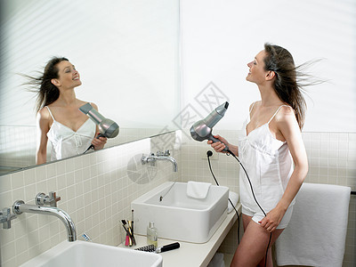 女人在浴室里烘干头发图片