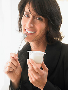 女人微笑着吃酸奶图片