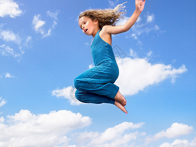 拉伸天空在空中跳跃的年轻女孩背景