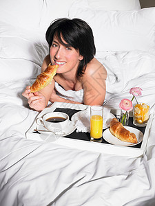 在床上吃早餐的女人图片