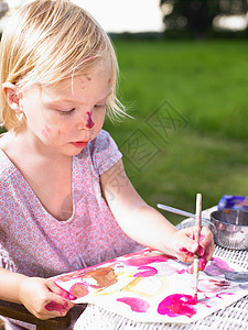 小女孩在绿地上画画图片
