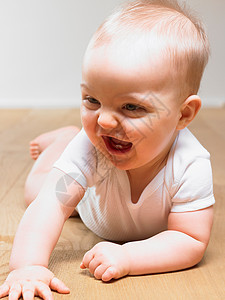 婴儿在地板上，微笑着图片