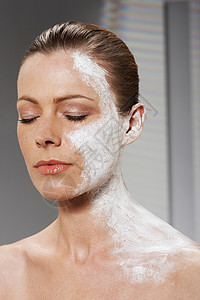 面部和颈部涂有润肤霜的女性图片