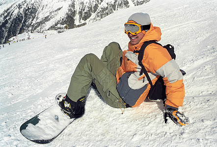 滑雪男子坐在雪地里图片