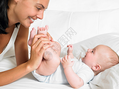 育婴箱母亲亲吻新生儿的脚背景